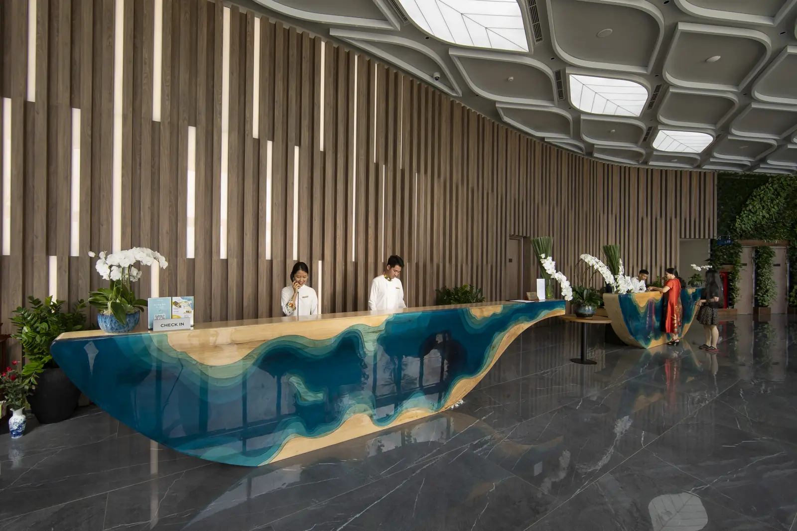 Quầy lễ tân uốn lượn màu xanh biển ở sảnh Flamingo Cát Bà Resort