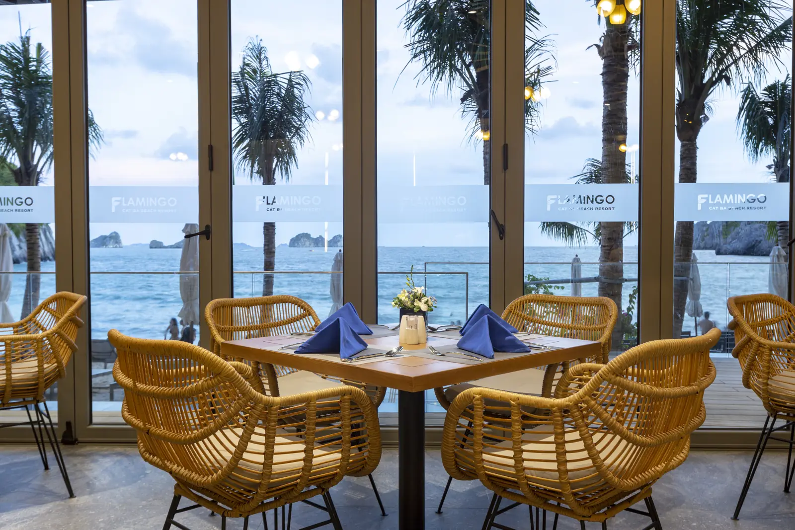 Bàn ăn bên cửa kính nhìn ra biển và đảo đá ở nhà hàng Flamingo Cát Bà
