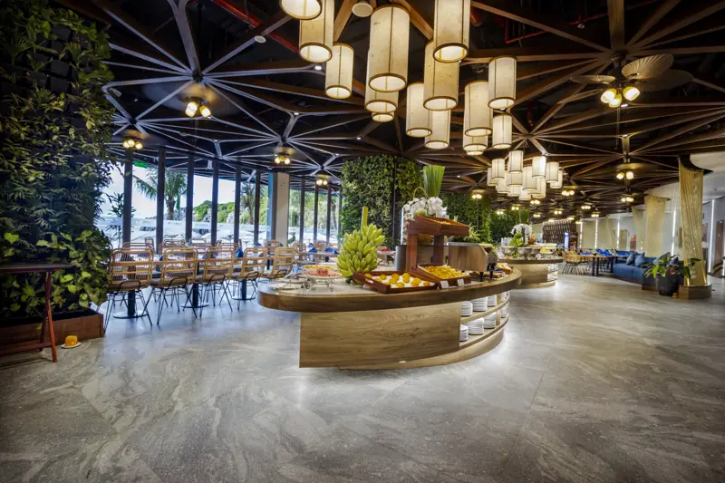Nhà hàng Flamingo Cát Bà với quầy buffet tròn, đèn lồng treo và cột cây xanh