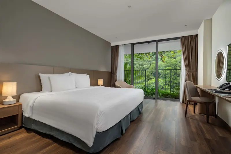 Phòng Deluxe Mountain View Flamingo Cát Bà, cửa kính nhìn ra rừng cây trên núi
