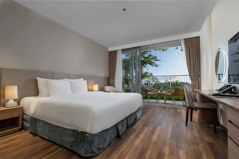 Phòng Premier Ocean View: giường đôi lớn, ban công có bàn ghế nhìn ra biển