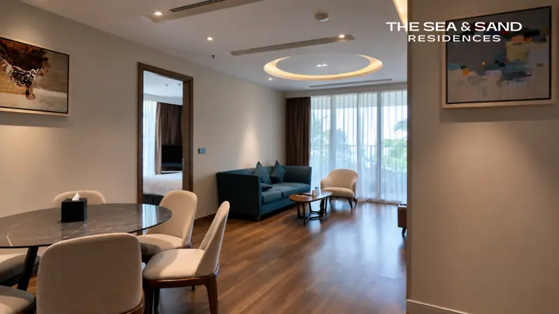 Căn hộ The Sea & Sand Residences: bàn ăn tròn, góc bếp và phòng khách sáng