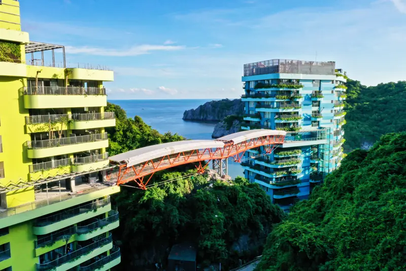 Cầu Mây đi bộ trên cao nối hai tòa nhà Flamingo Cát Bà, phía sau là biển và núi đá