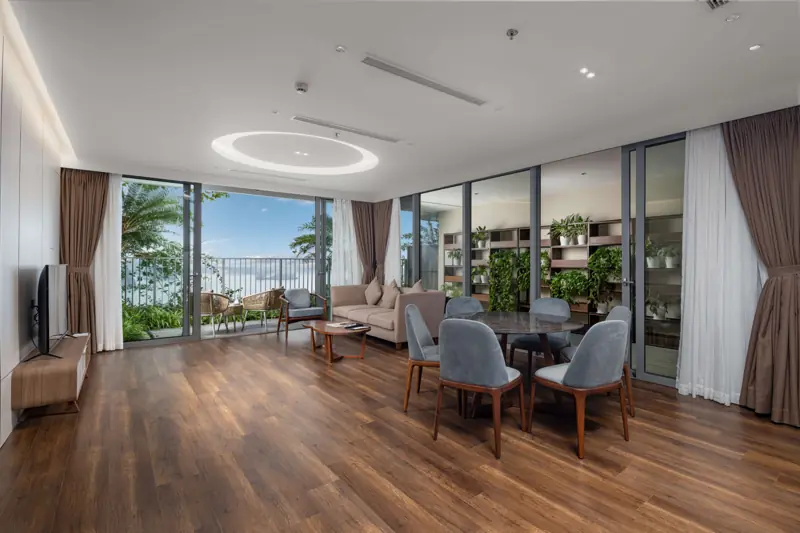 Phòng khách căn Residence với bàn ăn và cửa kính nhìn ra cây xanh, Flamingo Cát Bà