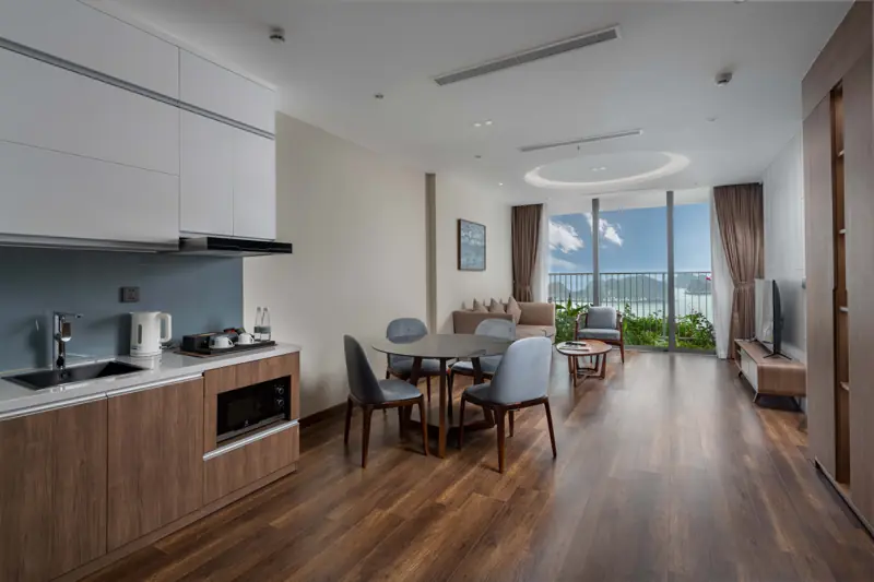 Căn Residence 1 phòng ngủ có bếp nhỏ, bàn ăn và phòng khách mở ra ban công nhìn biển